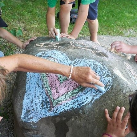 Kinder bemalen Fels mit einem Herzen